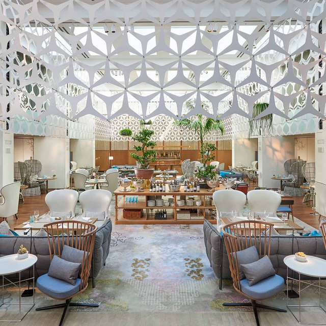 Lujoso salón del Hotel Mandarin Oriental Barcelona, con decoración moderna, techos altos, luz natural y cómodos asientos.
