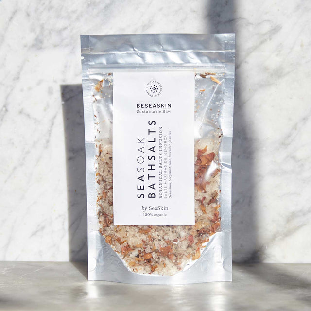 Envase de sales de baño de Beseaskin, 100% orgánicas a base de Geranio, Bergamota, Rosa, Lavanda y Jazmín con fondo de mármol.