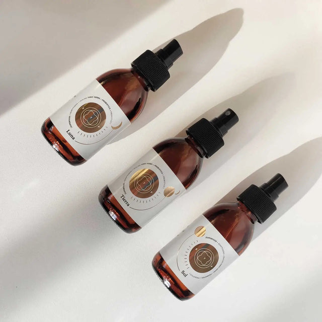 Envases de los elixires corporales Luna, Sol y Tierra de Smell The Planet, 100% orgánicos con hierbas tónicas curativas y probióticos, sobre superficie blanca.