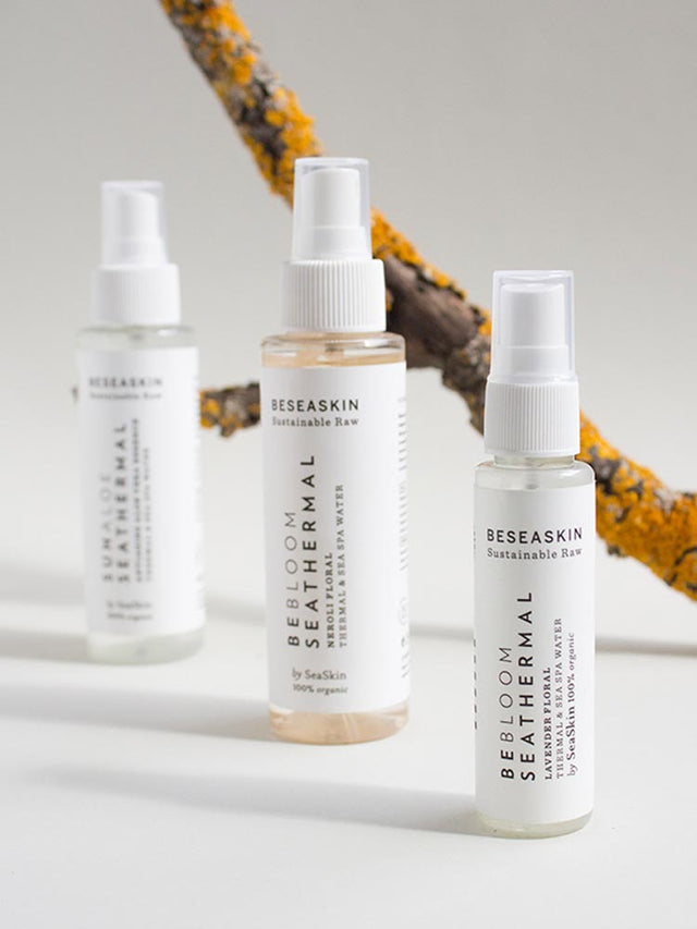 Sprays cosméticos orgánicos frente a una rama, resaltando su esencia natural y sostenible. Sprays cosméticos orgánicos frente a una rama, resaltando su esencia natural y sostenible.