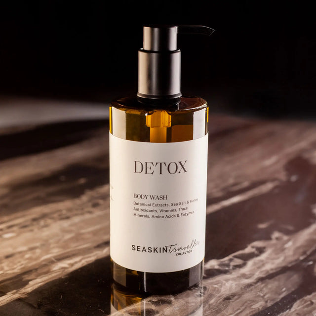 Botella con dispensador de gel de baño 'DETOX' de la colección SEASKIN Traveller. La etiqueta indica que contiene extractos botánicos, sal marina, yodo, antioxidantes, vitaminas, oligoelementos, aminoácidos y enzimas.