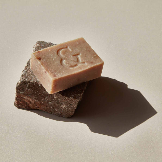 Jabón facial hidratante de Seaskin, 100% orgánico y artesanal, con Miel, Aceites y Propóleos sobre una piedra y fondo beige