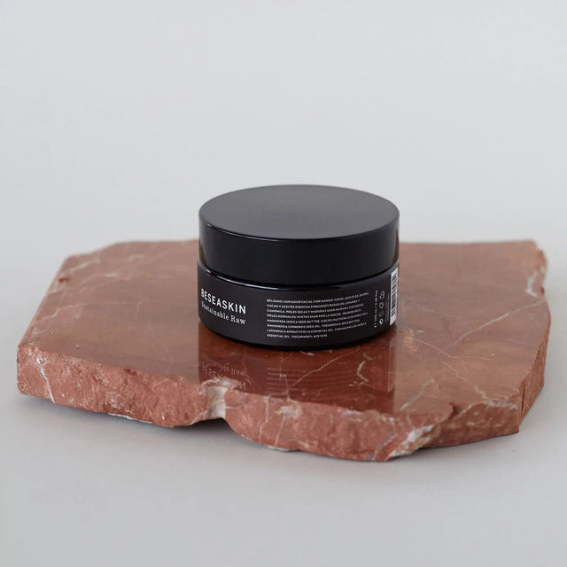 Bálsamo limpiador facial Bebalm  sobre piedra roja.