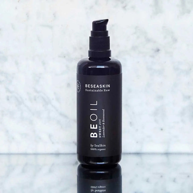 Envase de aceite corporal antiaging de Beseaskin, 100% orgánico a base de Lavanda y Palo de Rosa con fondo de mármol.