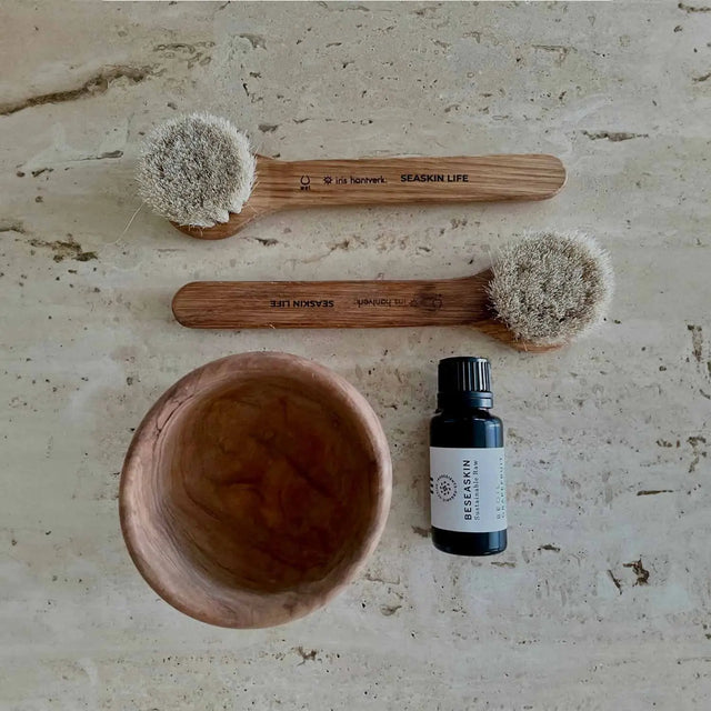 Dos cepillos faciales de limpieza en seco o húmedo con mango de madera y cerdas naturales.