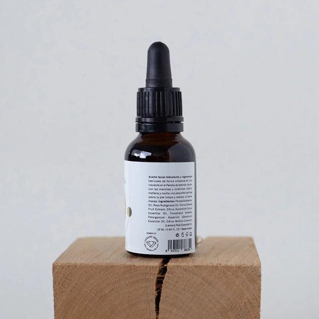 Suero facial Elixir IO en gotero ámbar mostrando ingredientes e información de la etiqueta trasera.