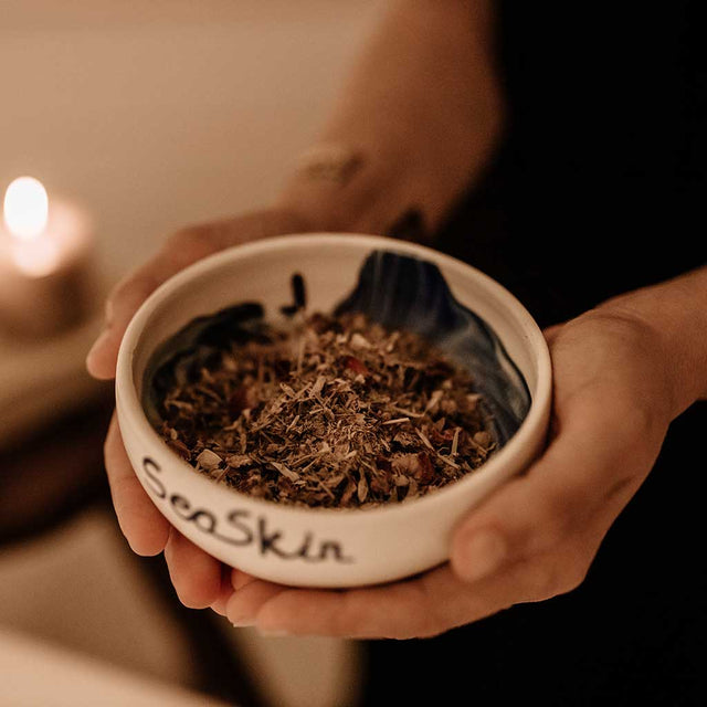 Cerámica de Seaskin con infusión floral de Beseaskin, 100% orgánica a base de Jazmín y Caléndula sobre unas manos.