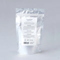 Envase de sales de baño de Beseaskin, 100% orgánicas a base de Geranio, Bergamota, Rosa, Lavanda y Jazmín con fondo gris.