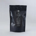 Envase de bálsamo exfoliante corporal nutritivo de Beseaskin, 100% orgánico a base de Sándalo y Naranja con fondo gris.