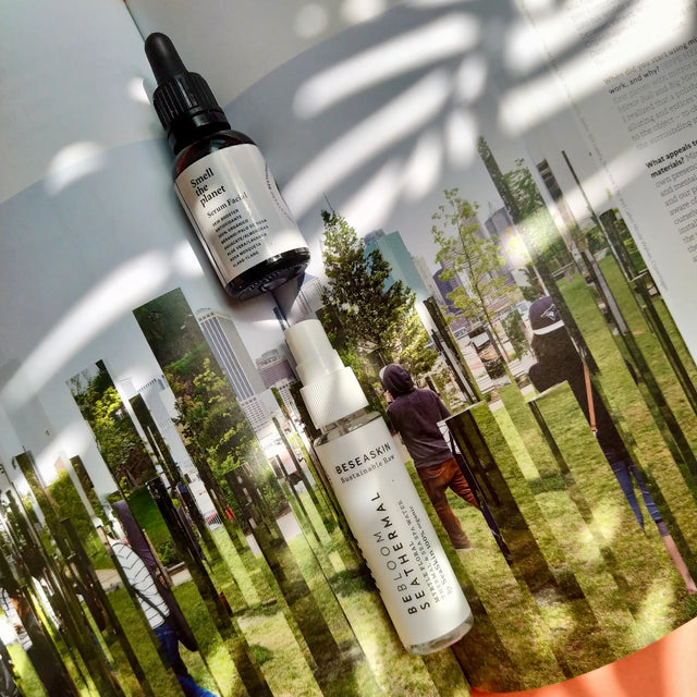 Envases de bruma floral facial de Mirto reafirmante y aceite facial Ío hidratante y regenerador, 100% orgánicos sobre revista con foto de naturaleza.