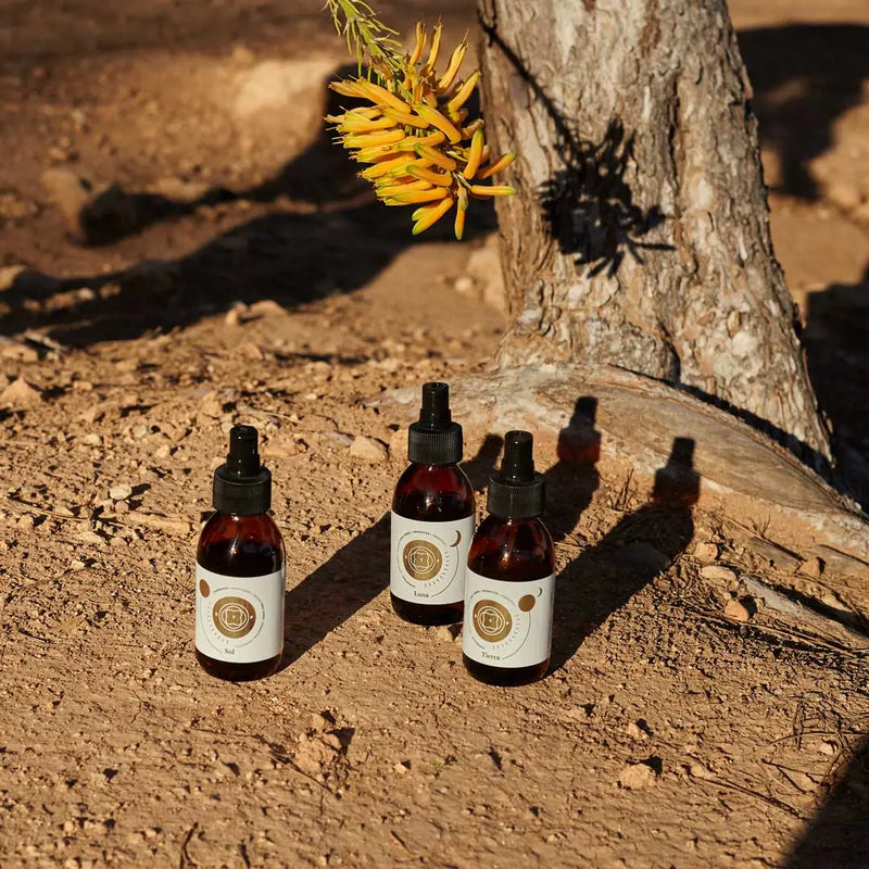 Envases de los elixires corporales Luna, Sol y Tierra de Smell The Planet, 100% orgánicos con hierbas tónicas curativas y probióticos, con fondo de naturaleza.