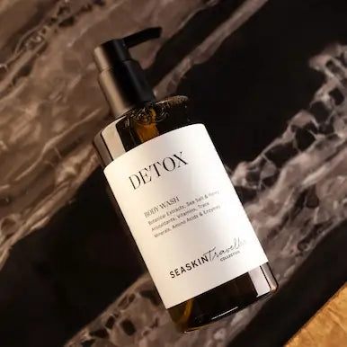 Botella con dispensador de gel de baño 'DETOX' de la colección SEASKIN Traveller. La etiqueta indica que contiene extractos botánicos, sal marina, yodo, antioxidantes, vitaminas, oligoelementos, aminoácidos y enzimas.