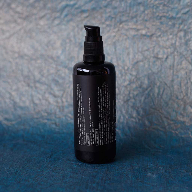 Envase de aceite corporal tonificante de Beseaskin, 100% orgánico a base de Menta y Tomillo con fondo azul oscuro.